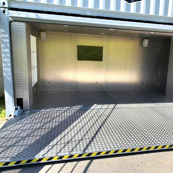 Container stand evenementiel vue intérieur en ALU strié et disposant de sa plate forme ouverte sur l'avant afin d'agrandir l'espace d'exposition, l'evenemnt se déroule au Gets pour la compétition de VTT organisé par red bull. yaute box